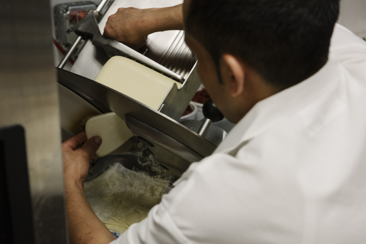 Kitchen staff slicing mozzarella cheese