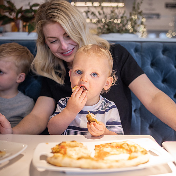 Mother and toddler boy enjoying pizza