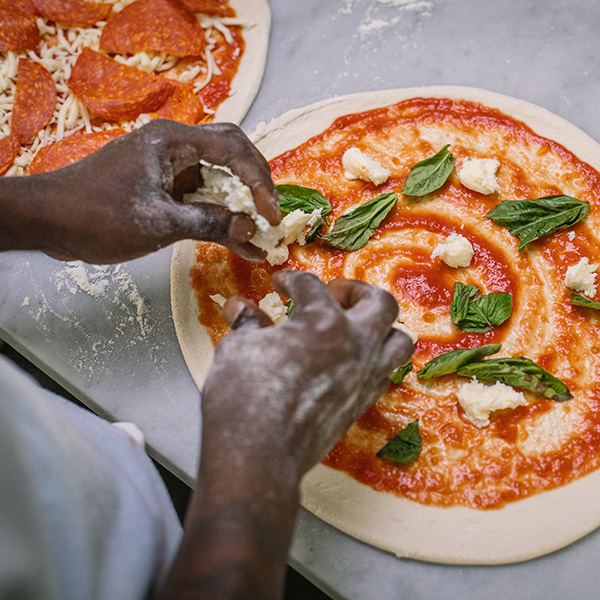 Making Neapolitan pizza that features Grande fresh mozzarella cheese